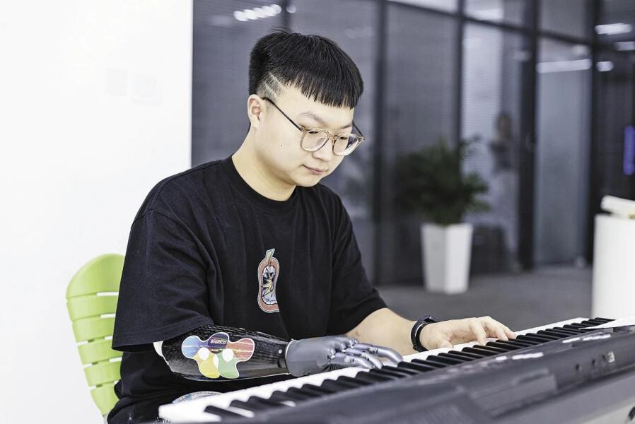 Photo shows Zhou Jian playing piano with his bionic hand.(Photos provided by interviewees.) Photo shows Zhou Jian playing piano with his bionic hand.(Photos provided by interviewees.)