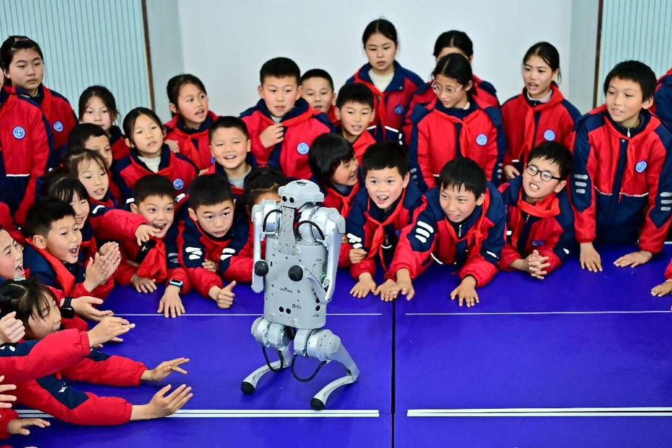 At a primary school in Fuzhou, east China's Jiangxi province, students watch intently as a quadruped robot demonstrates its AI capabilities during class. (Photo by Zhu Haipeng/People's Daily Online)