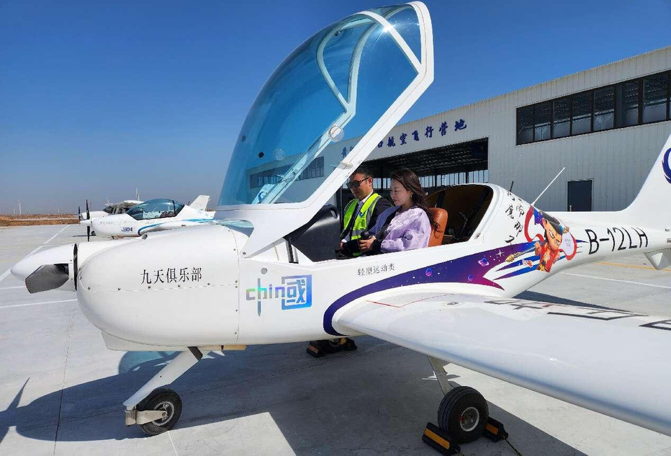 A flight instructor takes a tourist up in a small fixed-wing aircraft during an aviation camp in Dongying, east China's Shandong province. (Photo by Zhou Guangxue/People's Daily Online)
