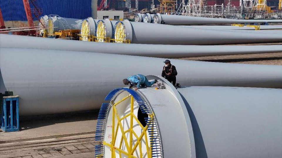 Workers assemble a massive wind turbine blade at a marine wind power industrial base in Rongcheng city, east China's Shandong province. (Photo by Yang Zhili/People's Daily Online)