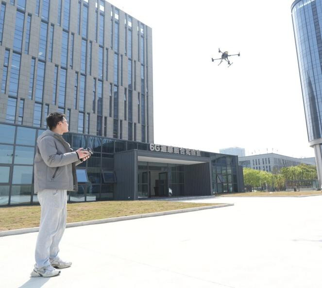 A staff member of the Regional University–Industry Technology Transfer Center (Jiangsu) operates a 6G-enabled drone for technical verification. (Photo by Pang Chengchen)