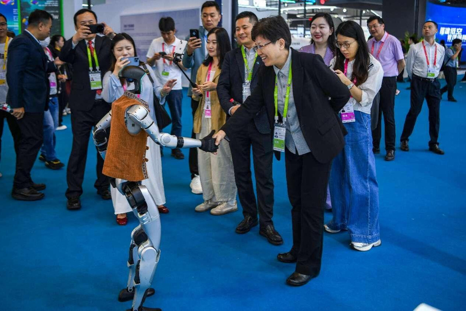 A robot developed by Unitree Robotics shakes hands with an exhibitor representative at the 5th China International Consumer Products Expo (CICPE) held in south China's Hainan province, April 14, 2025. (Photo by Su Bikun/People's Daily Online)