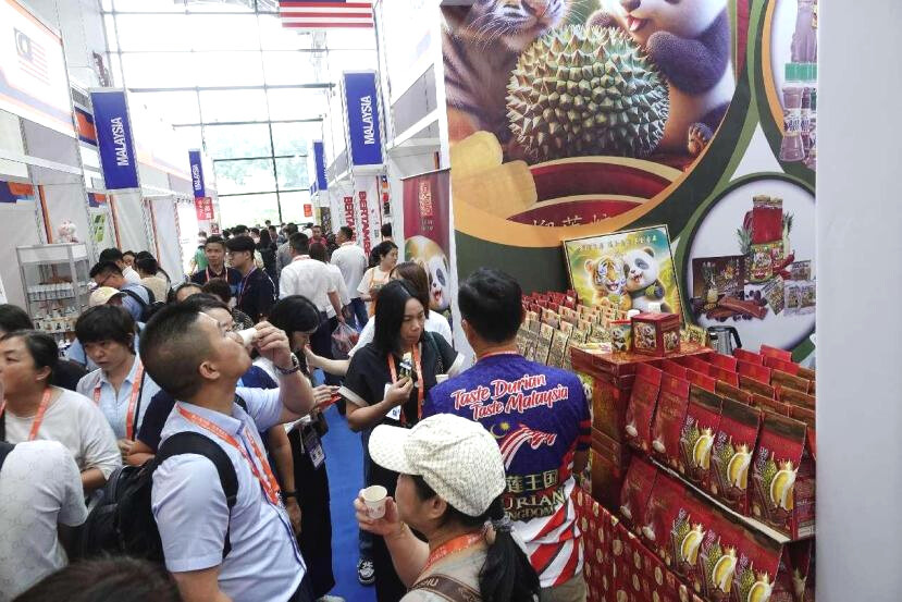 Photo taken on Sept. 24, 2024 shows visitors selecting products at the booth of Malaysia during the 21st China-ASEAN Expo in Nanning, south China's Guangxi Zhuang autonomous region. (Photo by Yu Xiangquan/People's Daily Online)