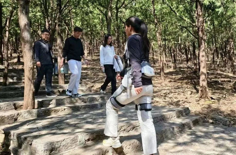 A tourist climbs stairs with a hiking aid device in Yunmen Mountain scenic area in east China's Shandong province. (Photo provided by Yunmen Mountain scenic area)