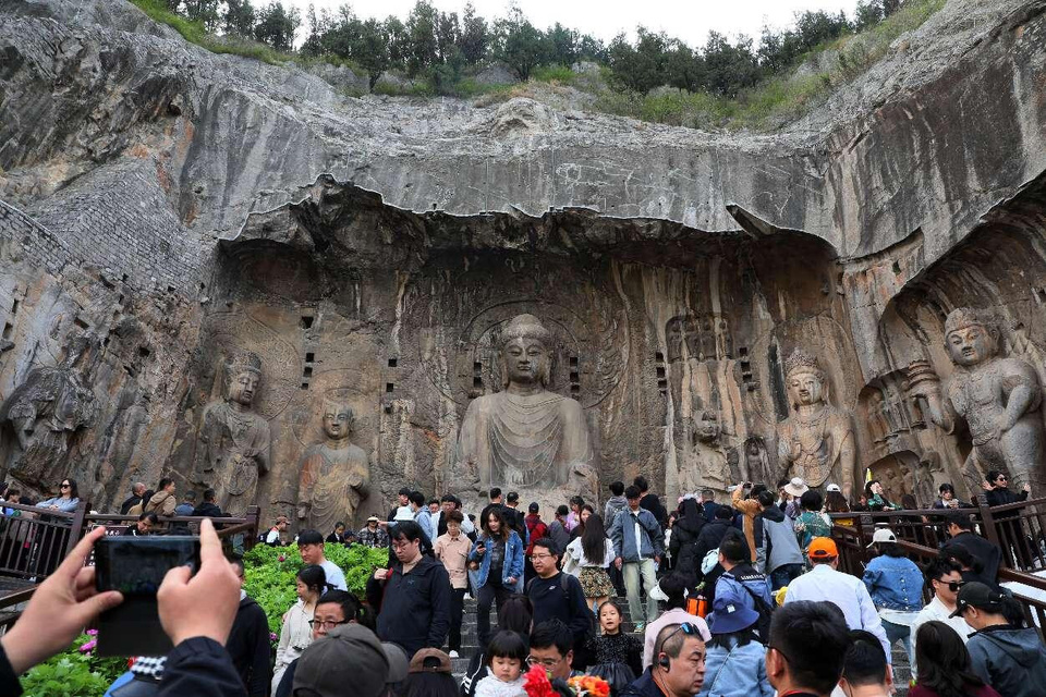 Tourists visit the Longmen Grottoes in Luoyang, central China's Henan province. (Photo by Shi Guangming/People's Daily Online)