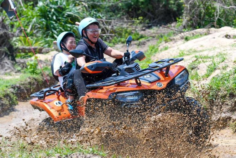 Tourists ride an all-terrain vehicle in Xitou village, Lingshan township, Haikou, south China's Hainan province. (Photo by Shi Zhonghua/People's Daily Online)