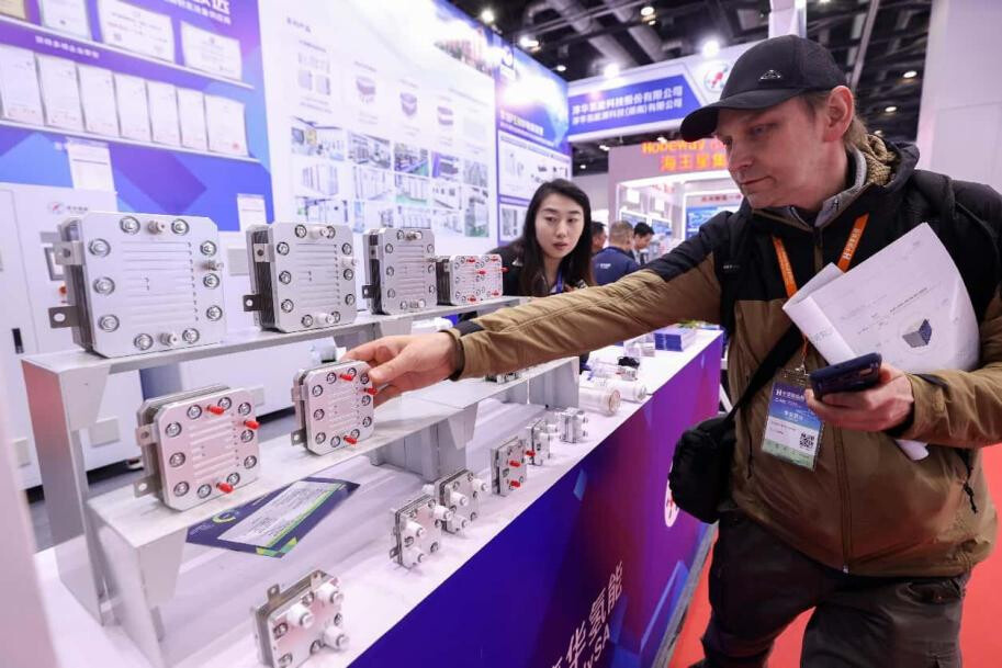 A foreign visitor learns about electrolyzers used for hydrogen production at the 15th Clean Energy Expo China (CEEC 2025) in Beijing, March 27, 2025. (Photo by Chen Xiaogen/People's Daily Online)