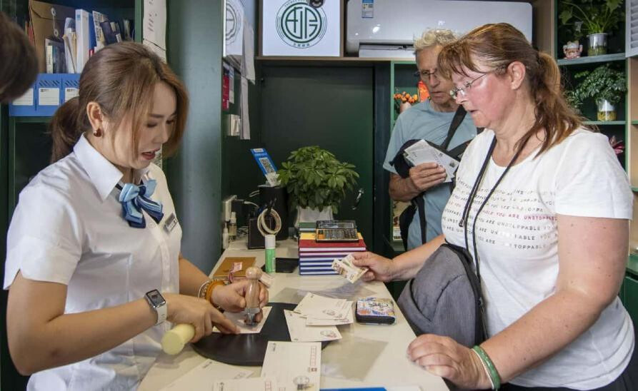 A foreign tourist mails postcards in a post office on the ancient city wall of Xi'an, northwest China's Shaanxi province, June 19, 2025. (Photo by Weng Qiyu/People's Daily Online)