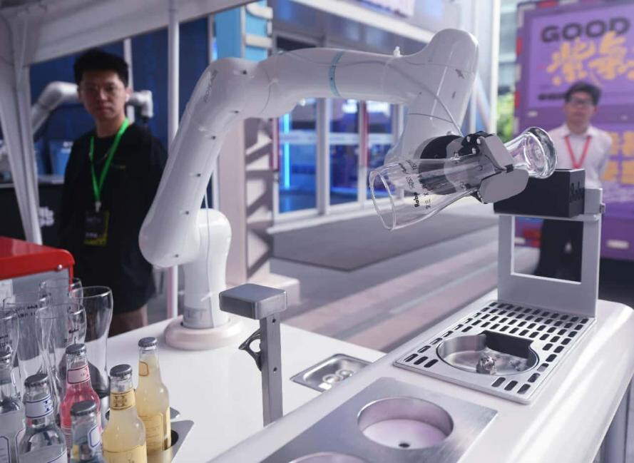 An AI robot makes a drink for consumers in a commercial district in Hangzhou, east China's Zhejiang province. (Photo by Long Wei/People's Daily Online)