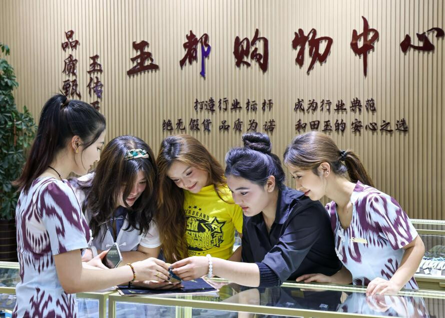 Tourists shop at a jade store in Hotan, northwest China's Xinjiang Uygur autonomous region. (Photo by Xu Xiaolong)