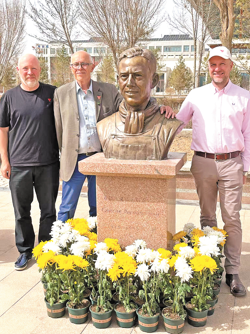 Mark Aylwin Thomas (second from left) poses for a picture beside the statue of George Aylwin Hogg. (Photo provided by the author)