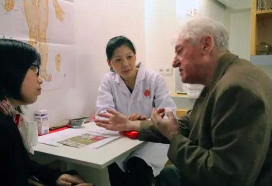 Des médecins chinois interrogent un patient tchèque dans une boutique Tong Ren Tang du centre de Prague. (Photo : Guan Kejiang pour le Quotidien du Peuple.)