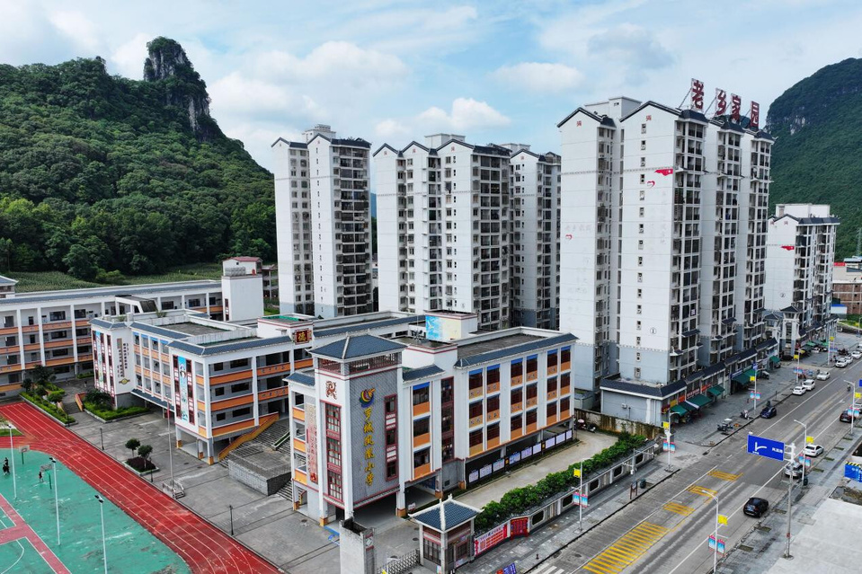 Photo shows a relocation site for poverty alleviation and a nearby elementary school in Luocheng Mulao autonomous county, Hechi, south China's Guangxi Zhuang autonomous region. (Photo/Wei Rudai)