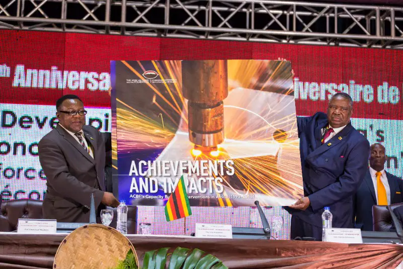 Le Vice-président de la République du Zimbabwe, Phelekezela Mphoko à (droite) présente le livre commémoratif intitulé "ACBF in Action, 25 years of capacity development impact across Africa".