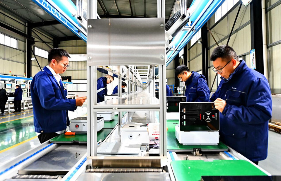 Workers test charging facilities at a workshop of a power transformation equipment manufacturer in Fuzhou, east China's Jiangxi province. (Photo/Zhu Haipeng)
