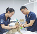 Jin Yipeng (right) guides a student in using the examination equipment. (Photo/Yang Hao)